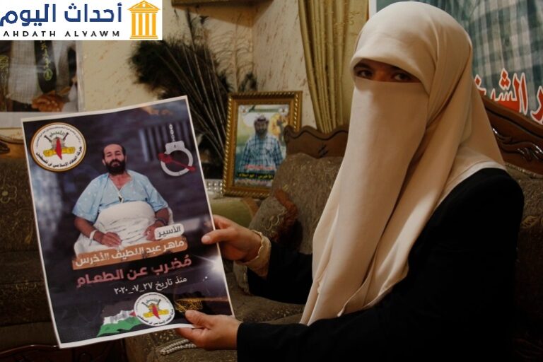 زوجة الأسير ماهر الأخرس تحمل صورته داخل منزلها