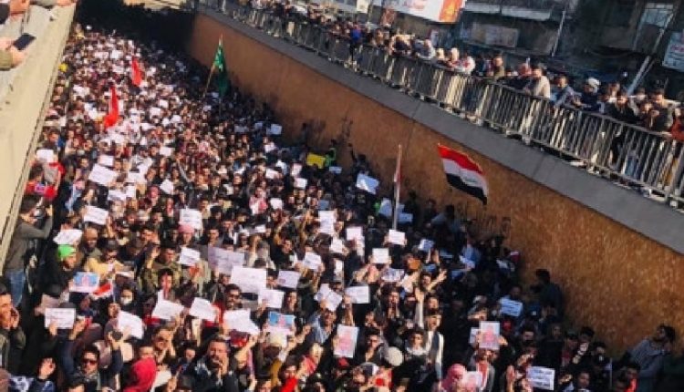 متظاهرون عراقيون يسيرون في ساحة التحرير - بغداد