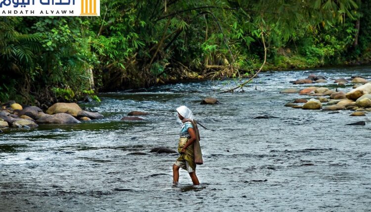 سيّدة تعبر نهرا في جامبي بإندونيسيا