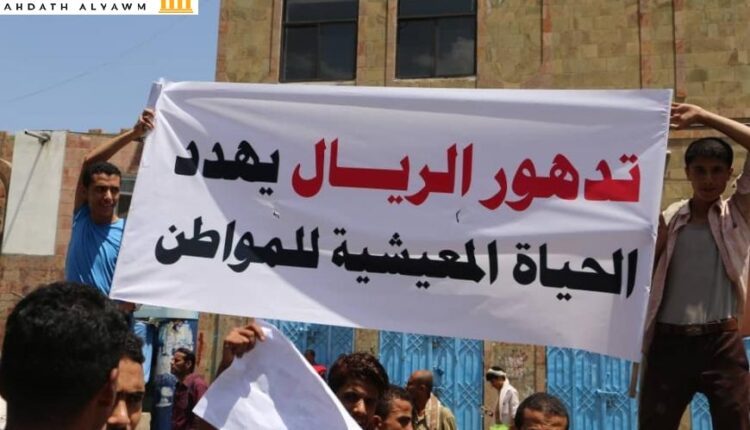 متظاهرون يحملون لافتة تقول: "تدهور الريال يهدد الحياة المعيشية للمواطن"، تعز، اليمن