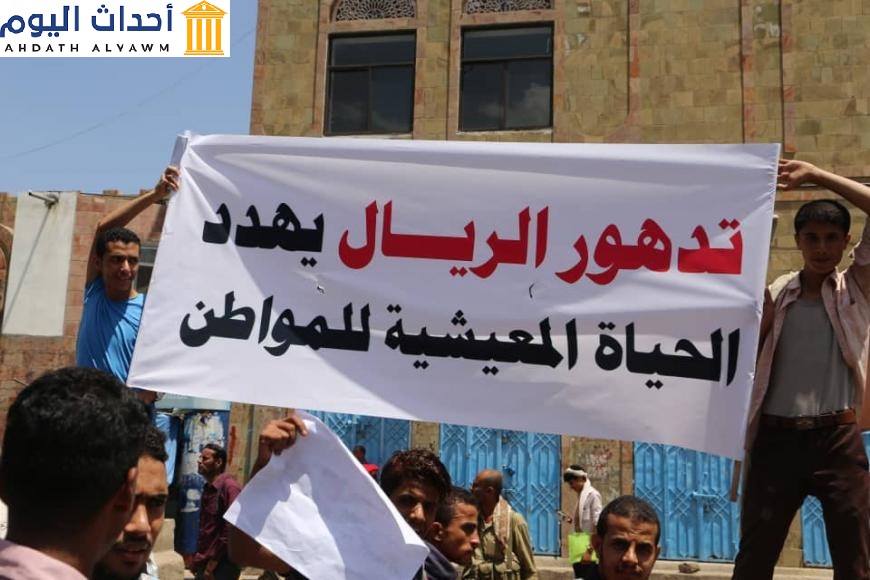 متظاهرون يحملون لافتة تقول: "تدهور الريال يهدد الحياة المعيشية للمواطن"، تعز، اليمن