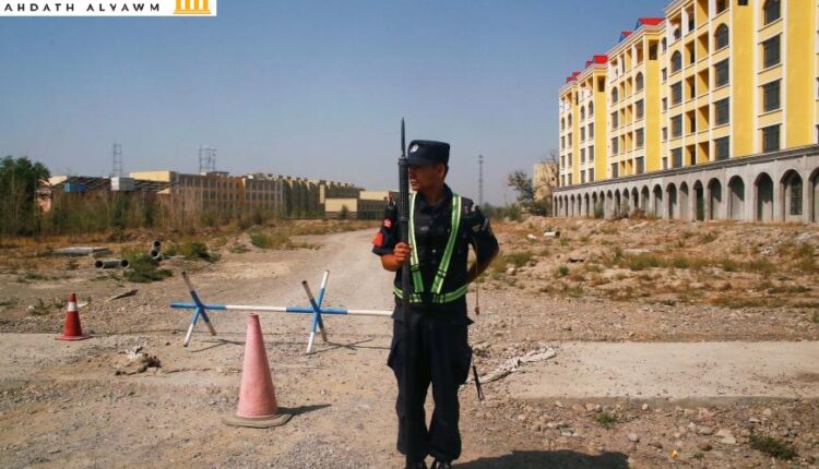 شرطي صيني يحرس الطريق بالقرب من مخيّم لـ"إعادة التأهيل" في ينينيغ، شينجيانغ