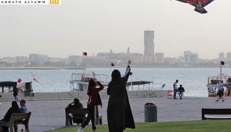 فتاة وامرأة يطيّران طائرة ورقية على الكورنيش في العاصمة القطرية الدوحة