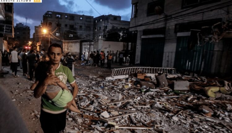 فلسطيني يحمل طفله بعد قصف إسرائيلي على غزة