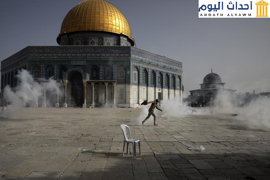 فلسطيني يهرب من الغاز المسيل للدموع الذي أطلقته قوات الأمن الإسرائيلية أمام مسجد قبة الصخرة في مجمّع المسجد الأقصى، القدس الشرقية المحتلة