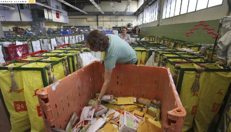 عاملون في البريد الإسرائيلي يصنفون البريد في مكتب للبريد في مدينة تل أبيب