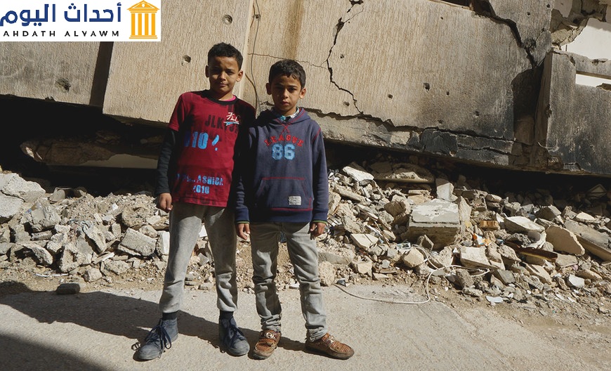 : طفلان يقفان أمام مبنى مدمر في بنغازي