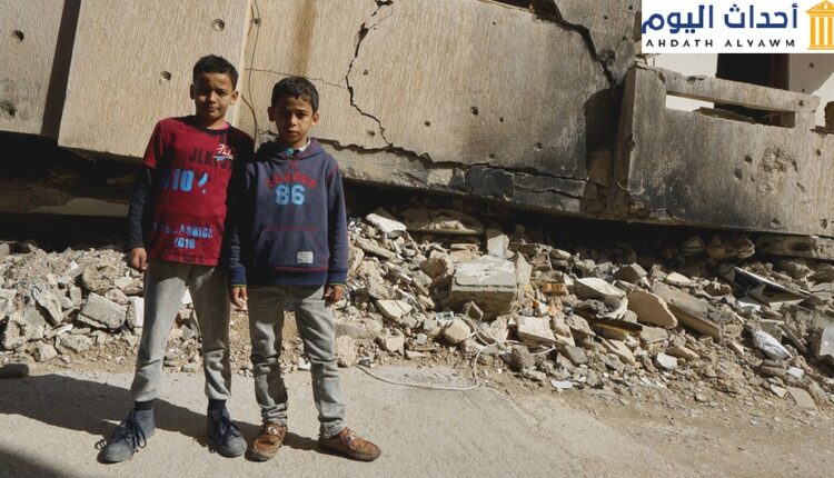 طفلان يقفان أمام مبنى مدمر في بنغازي