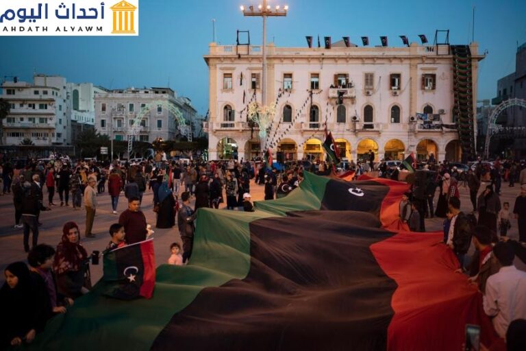 أشخاص يحملون علم ليبيا في ساحة الشهداء خلال مسيرة لإحياء ذكرى المظاهرات في طرابلس، ليبيا