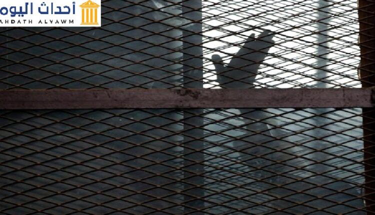 صورة أرشيفية لأحد أعضاء جماعة الإخوان المسلمين يلوح بيده من داخل قفص المتهمين في قاعة محكمة بسجن طرة، جنوب القاهرة، 22 آب/أغسطس 2015