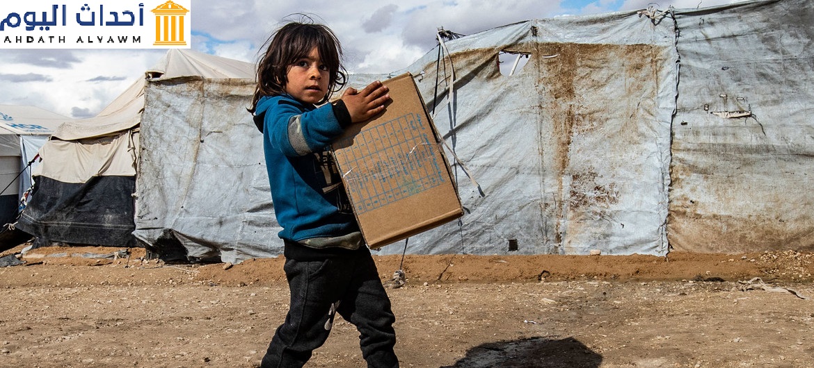 طفلة تحمل مستلزمات شتوية توزعها اليونيسف في مخيم الهول شمال شرق سوريا