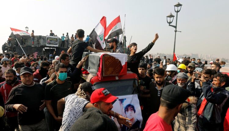 أشخاص في موكب تشييع يحملون نعش أحد المحتجين الذين قتلوا أثناء مظاهرة في بغداد