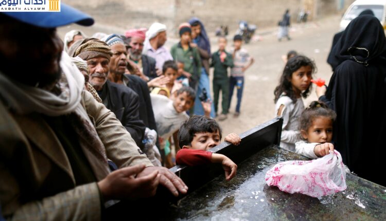 أشخاص يصطفون في طابور لتحصيل حصص غذائية في مركز توزيع المواد الغذائية في صنعاء، اليمن