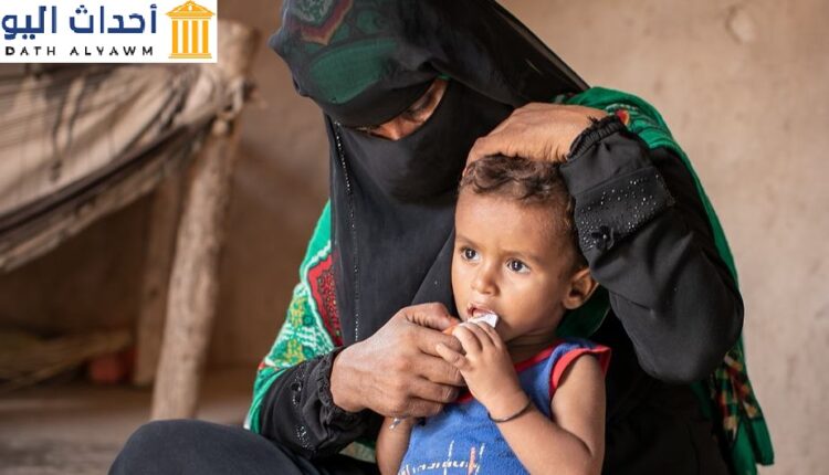 امرأة تجلس مع ابنها في منزل العائلة المؤقت في لحج ، اليمن