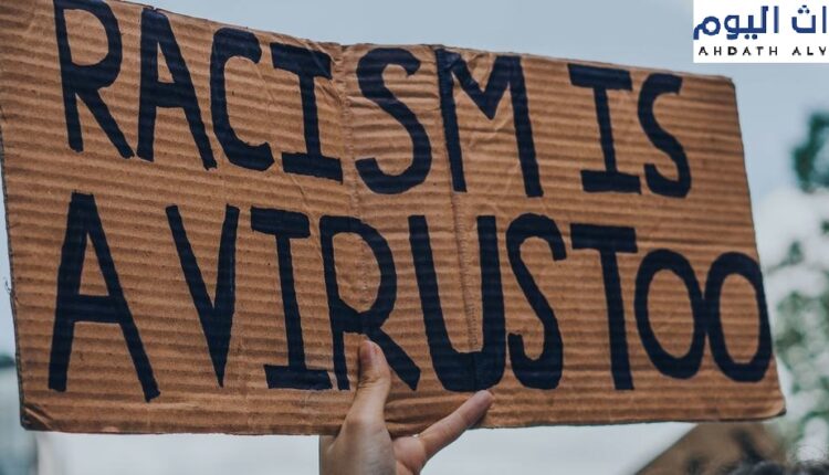 شخص يرفع علامة مكتوب عليها العنصرية هي أيضا فيروس