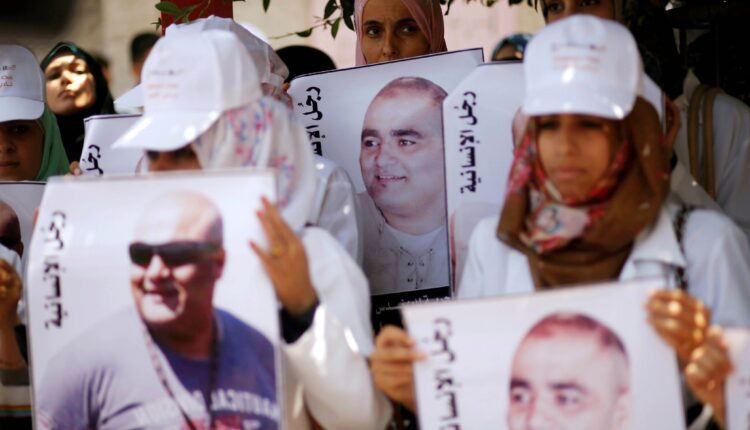 متظاهرون فلسطينيون يحملون صور محمد الحلبي، مدير عمليات "وورلد فيجين" في مدينة غزة، 7 أغسطس/آب 2016، تضامنا معه. اتهمته إسرائيل بتحويل أموال معونات بملايين الدولارات إلى "حماس"