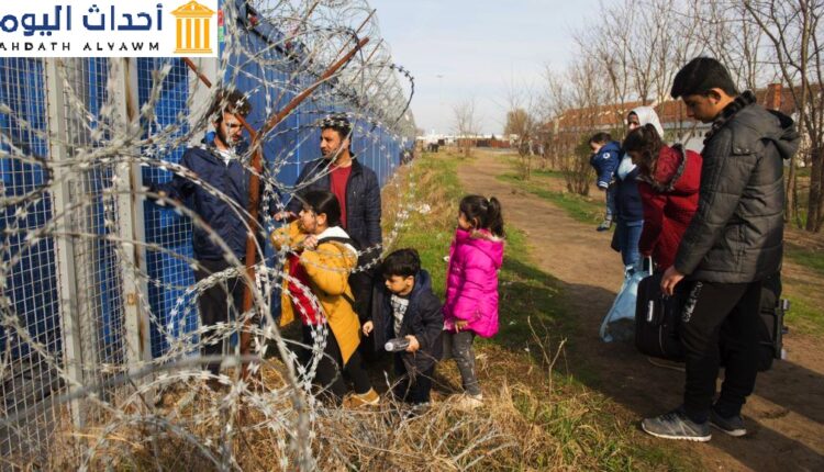 عائلة تنتظر عند البوابة بعد أن تم اختيارها لطلب اللجوء في المجر