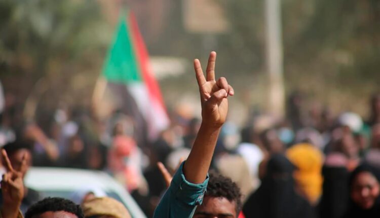 متظاهرون مؤيدون للديمقراطية يرفعون إشارة النصر بعدما نزلوا إلى الطرقات لإدانة استيلاء ضباط الجيش على السلطة، في الخرطوم