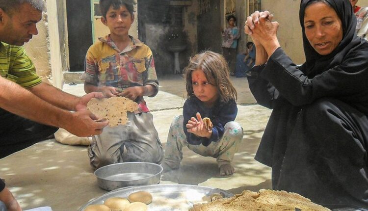 عائلة تأكل الخبز المصنوع على فرن الحطب والطحين المقدم من برنامج الأمم المتحدة الإنمائي في سوريا