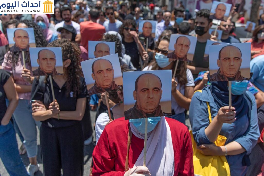 متظاهرون يحملون صور الناشط نزار بنات خلال مظاهرة في مدينة رام الله في الضفة الغربية في اليوم نفسه الذي ضُرب فيه حتى الموت أثناء احتجازه من قبل السلطة الفلسطينية