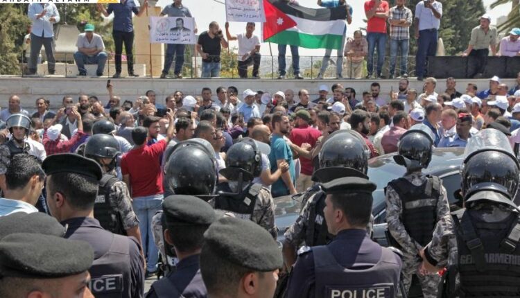 معلمون أردنيون يحملون علمهم الوطني خلال مظاهرة في العاصمة عمّان