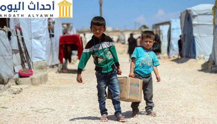 طفلان سوريان يحملان مساعدات إنسانية إلى خيمتهما في مخيم فافين بريف حلب الشمالي