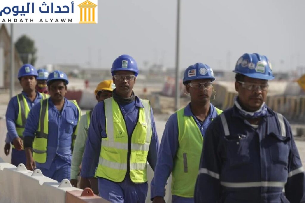 عمال يمشون في استاد "لوسيل، أحد الملاعب التي ستجرى فيها مباريات "كأس العام 2022"، في لوسيل، قطر