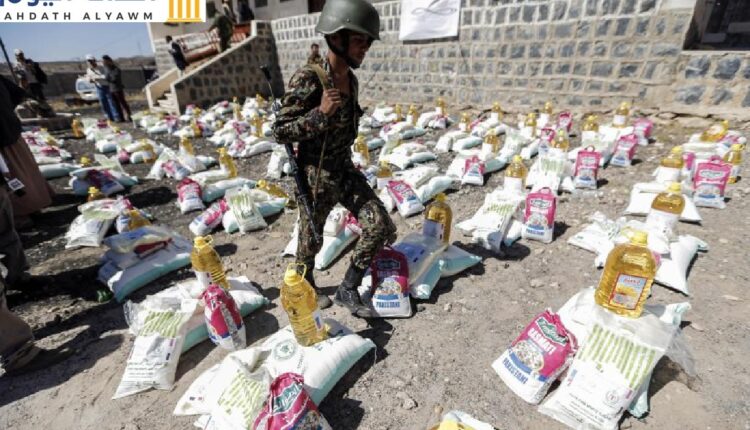 جندي مرتبط بالحوثيين يسير بين مواد إغاثية في مخيم للنازحين على أطراف العاصمة اليمنية صنعاء