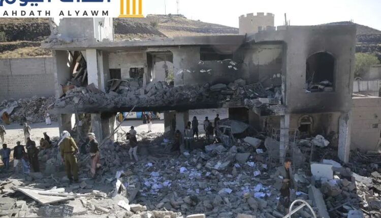 أشخاص يتفقدون مبنى متضررا في موقع غارة شنتها السعودية على صنعاء، اليمن