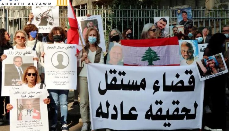 أهالي ضحايا إنفجار المرفأ يرفعون صور أحبائهم بالقرب من قصر العدل في بيروت في 25 نوفمبر/تشرين الثاني 2021. طالب الأقارب باستقلال القضاء لتحقيق العدالة