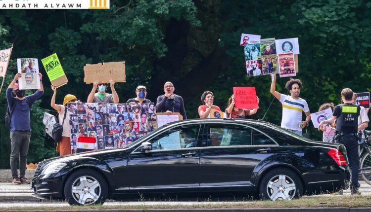 محتجون يحملون لافتات يهتفون خلال زيارة الرئيس المصري عبد الفتاح السيسي إلى ألمانيا في 18 يوليو/تموز 2022 في برلين