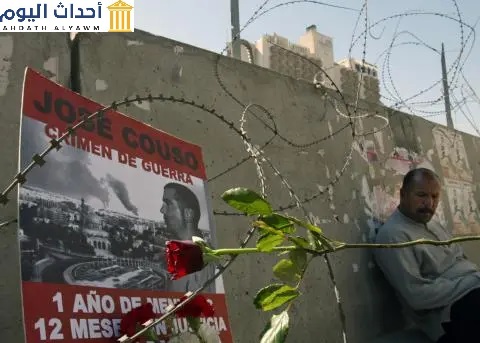 مُلصق تذكاري لخوسيه كوزي، المصور التلفزيوني الإسباني الذي قتله قذيفة أطلقتها دبابة أمريكية على فندق فلسطين في بغداد، معلق على متراس حاجز أمام مبنى الفندق