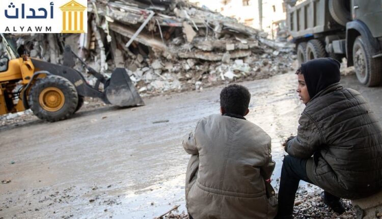طفلان ينظران إلى الأضرار التي سببها زلزال فبراير 2023 في شمال غرب سوريا