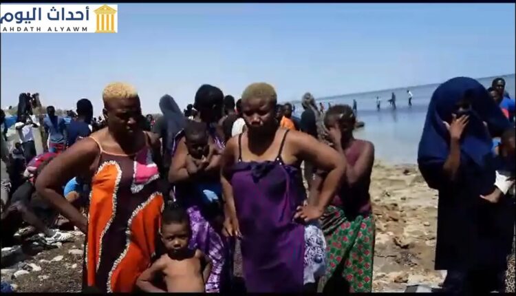 نساء وأطفال طردتهم السلطات الليبية إلى الحدود الليبية يقفون شاطئ البحر