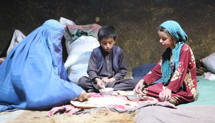 عائلة أفغانية تتناول طعاما حصلت عليه من الأمم المتحدة