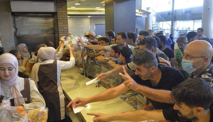 أشخاص ينتظرون دورهم للحصول على الخبز في مخبز في بيروت، لبنان، يوليو/تموز 2022