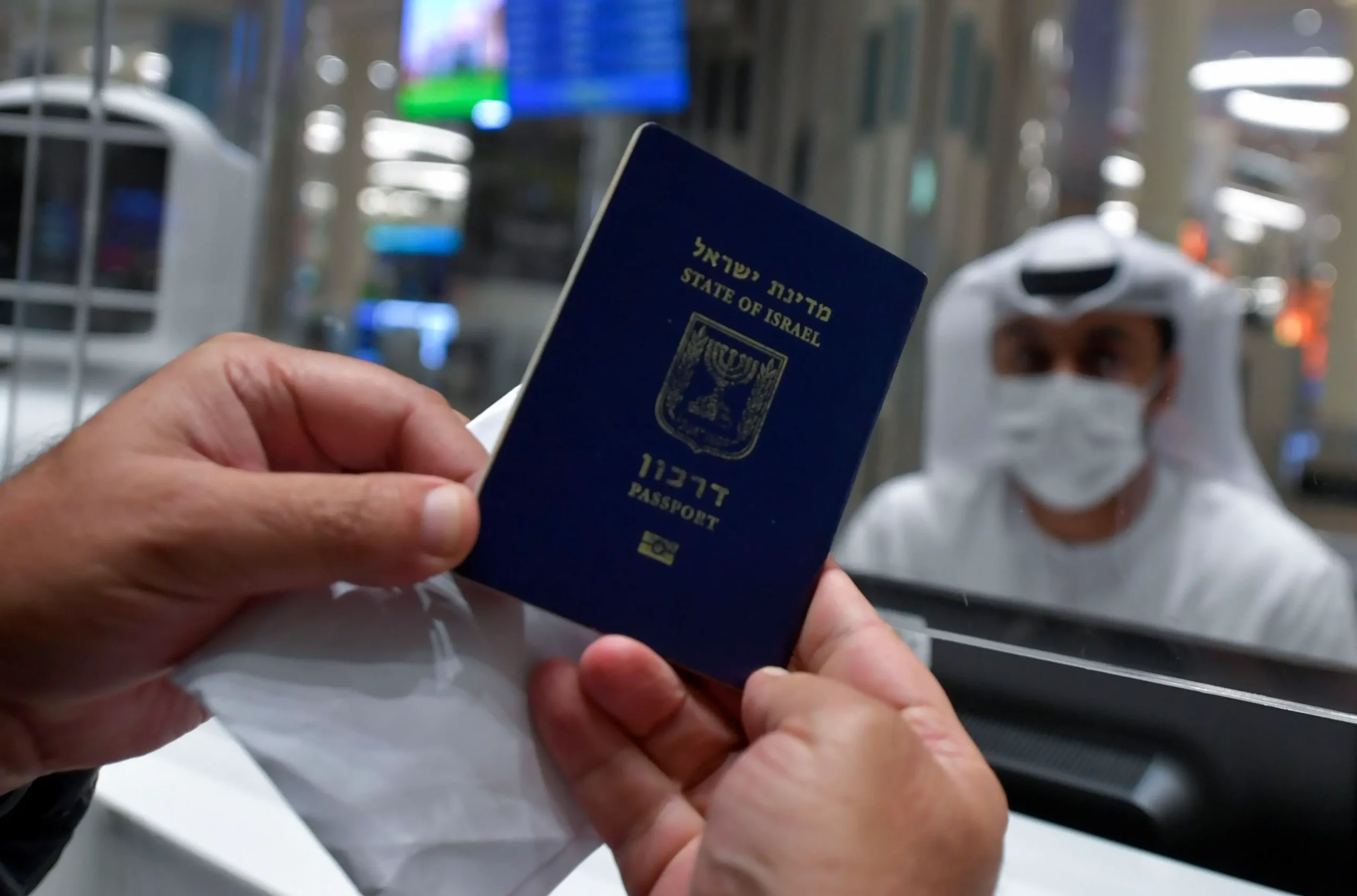 رجل إسرائيلي يقدم جواز سفره لضباط مراقبة الجوازات عندم وصوله من تل أبيب إلى مطار دبي في الإمارات